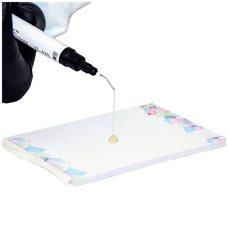 Cimento de ionômero de vidro em seringa Ionofast da Biodinâmica, mostrando a aplicação com a seringa em superfície branca